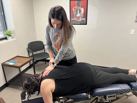 Chiropractor Cedar Rapids IA Sadie Wessels Adjusting Patients Back